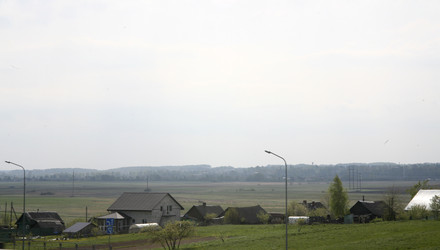 Сельский пейзаж с домами, полями и дорогой - Karagero