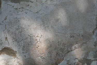 Текстура выветренной штукатурки с трещинами и светотенью. Weathered plaster wall texture with cracks and light shadows - Karagero