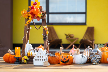осенняя концепция недвижимости с изображением маленькой модели белого дома с ключами на крыльце, заполненной оранжевыми тыквами и свечами - Simol1407