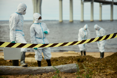 Разные ученые в защитных костюмах проверяют загрязнение воды - DragonImagesAsia