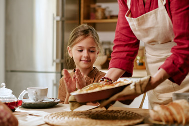 Пожилая женщина подает свежеиспеченный пирог счастливой девушке дома - AnnaStills